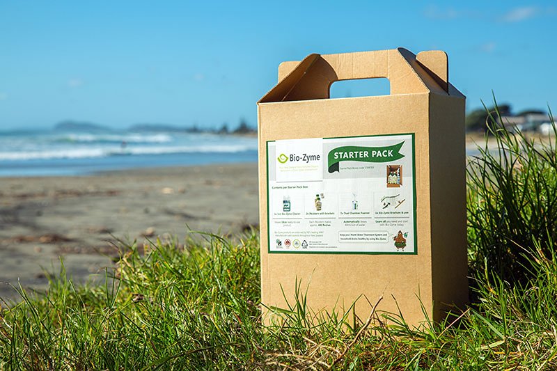 Bio-Zyme Starter Pack box standing on the grass in the beach showing a blue sky in the background